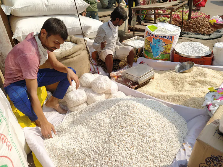 Un homme devant un étal de riz dans l’Uttar Pradesh en Inde