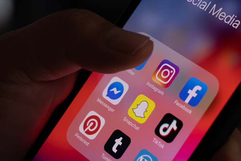 A thumb tapping the Twitter social media app on a phone screen