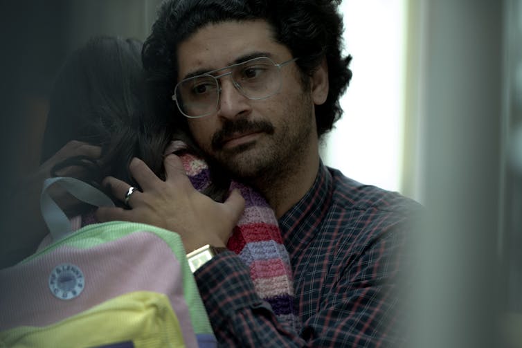 A man hugs his daughter.