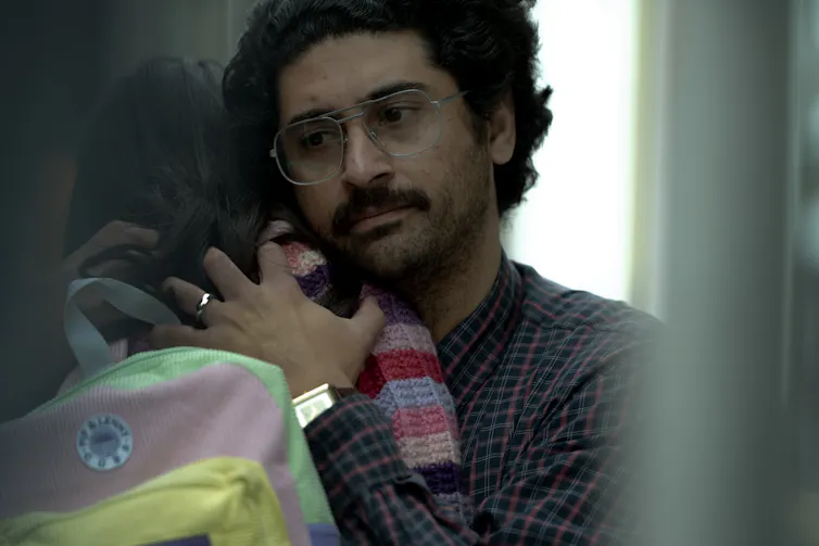 A man hugs his daughter.