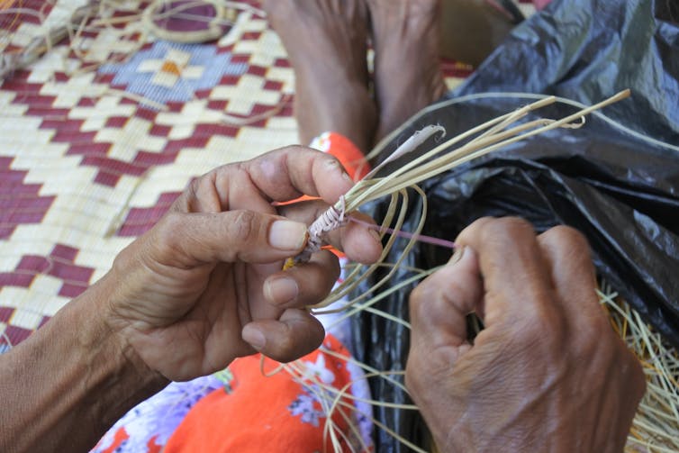 A close-up of hands weaving.