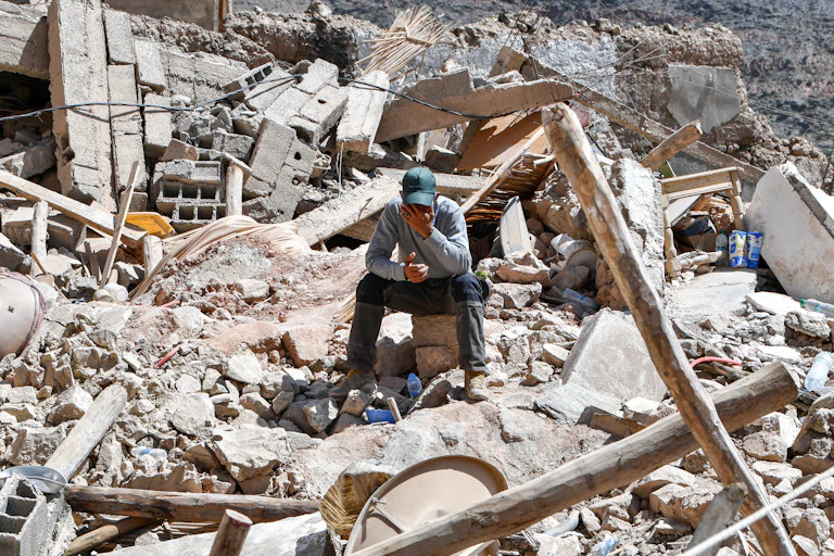 Un homme en pleurs dans les ruines d'un village