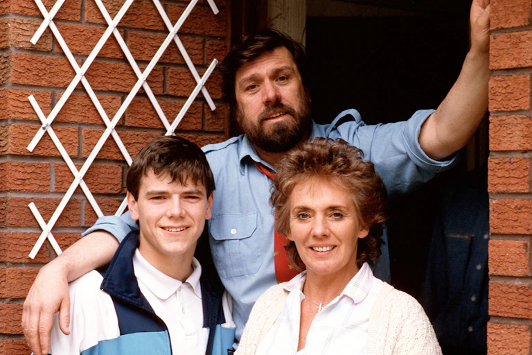 A photo of a fictional family from soap opera Brookside standing on the threshold of their home.