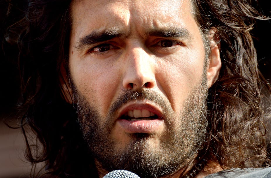 Close up photo of Russell Brand speaking into a microphone