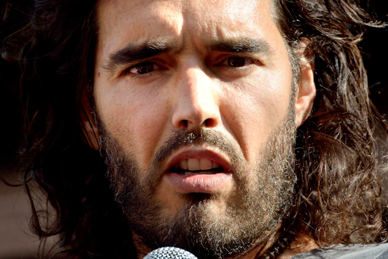 Close up photo of Russell Brand speaking into a microphone