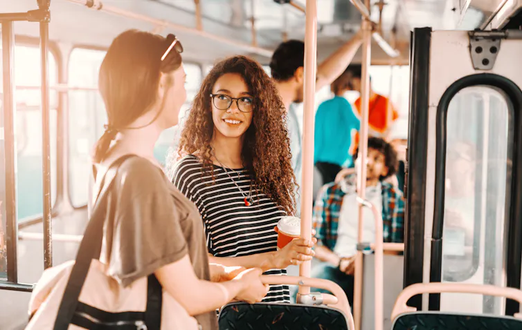 Deux jeunes femmes en train de discuter dans un bus