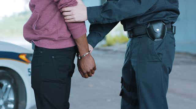 A police officer arresting a black man
