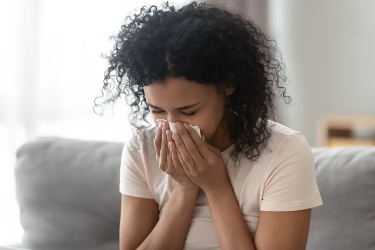 Woman sneezes