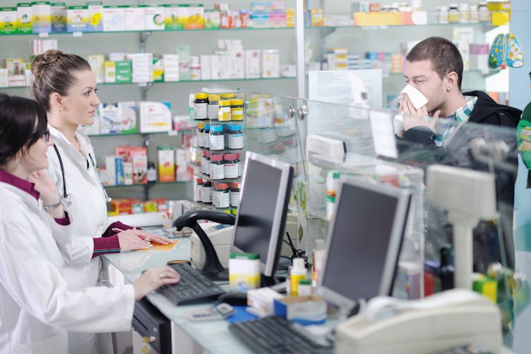 Man blows nose at pharmacy check out