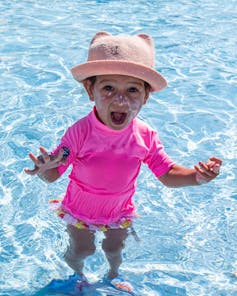 A young child shouts in a swimming pool.