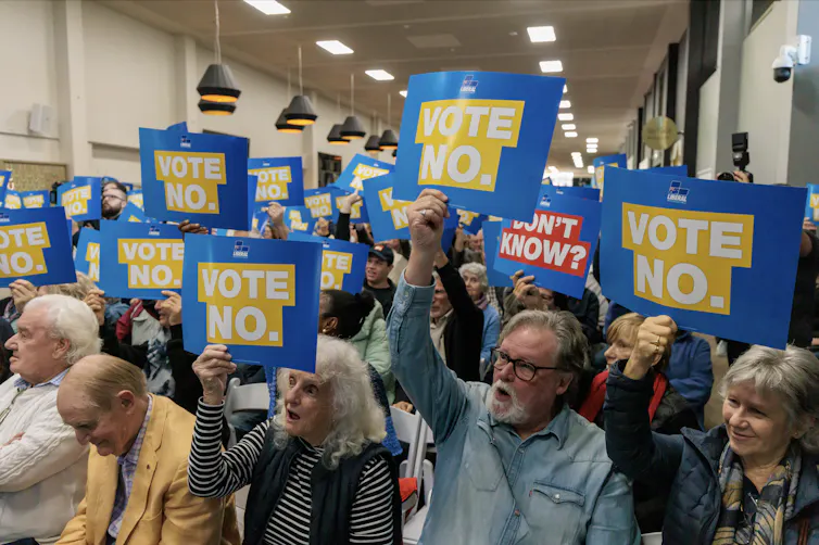 People holding up 'Vote no' signs