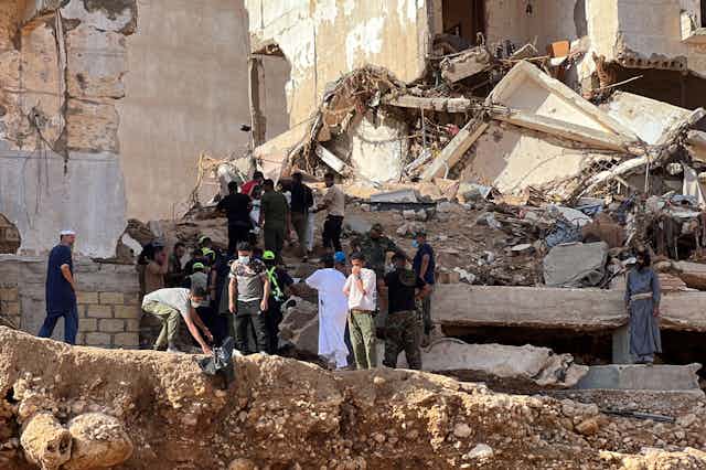 Groups of people search rubble for survivors of floods that devastated the city of Derna in eastern Libya.