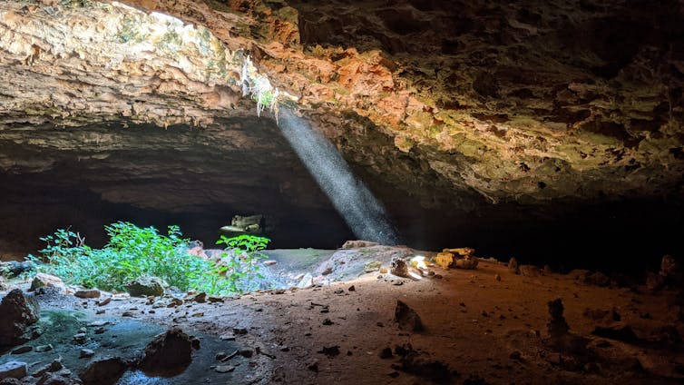 A shaft of sunlight penetrates a cave