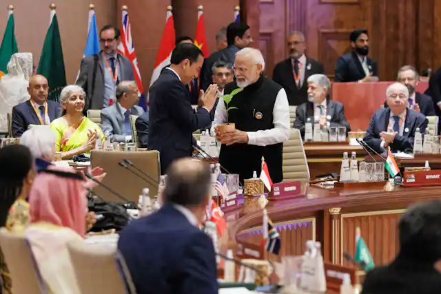 A group of world leaders meet with flags in background
