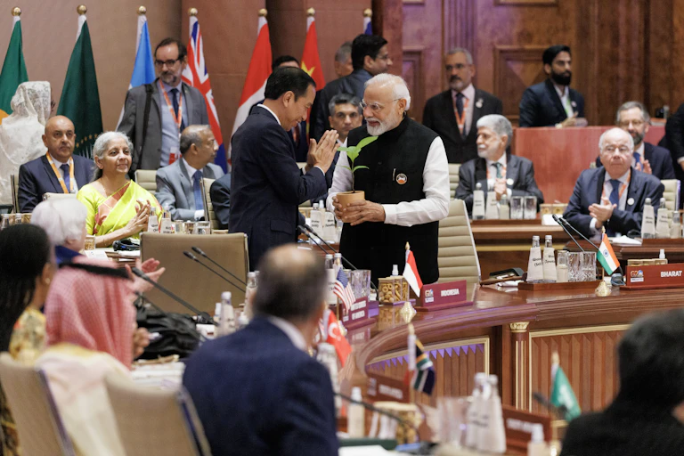 A group of world leaders meet with flags in background