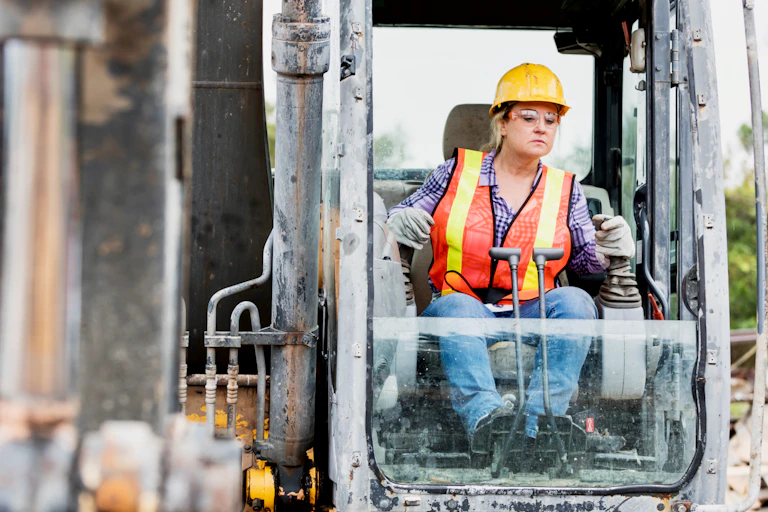Woman construction worker operating an earth mover.
