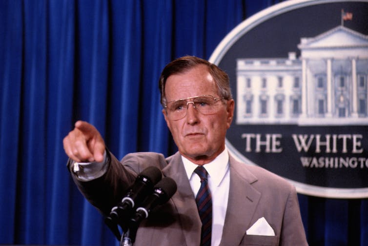 President George H.W. Bush points to a reporter to ask the next question during a news conference in the press briefing room at the White House.
