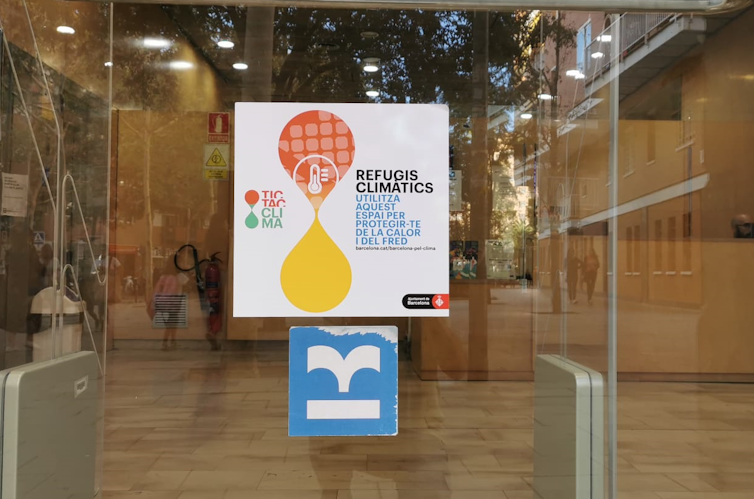 Cartel indicando un refugio climático en una puerta de cristal.