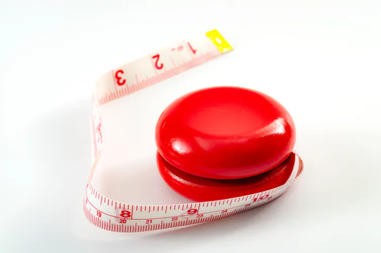 Un yo-yo rouge avec un mètre ruban à la place de la ficelle