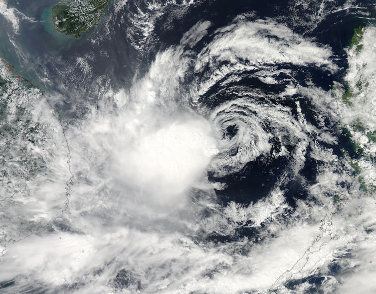 The top of the clouds is clearly offset from the center of the lower swirling clouds.