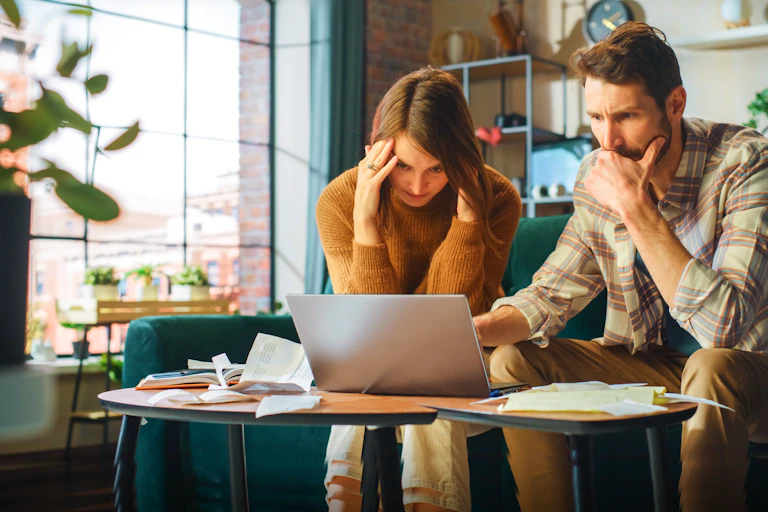 Man and women in kitchen look at laptop