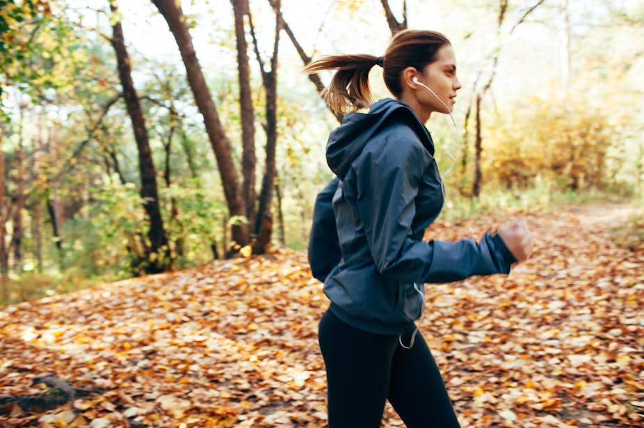 A young woman goes for an autumn run outdoors.