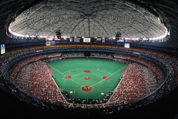 Panoramic view of domed baseball stadium with bright green artificial grass.