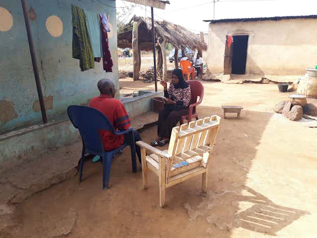 Deux personnes échangent dans une cour en Côte d'Ivoire