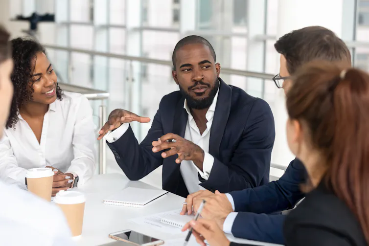 A group of people having a conversation around a conference table