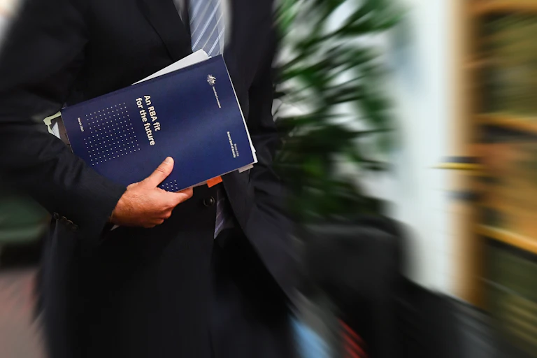 Person holding a copy of the Reserve Bank review