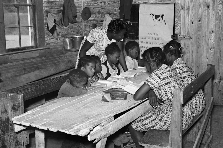 A Black teacher is holding class for six Black students.