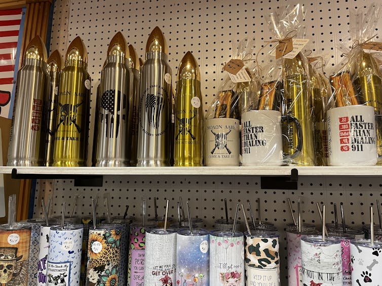 Store shelves show pointy, bullet-shaped silver and gold items next to novelty mugs.