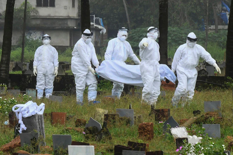 People in protective clothing carry the body of a person who died of Nipah virus