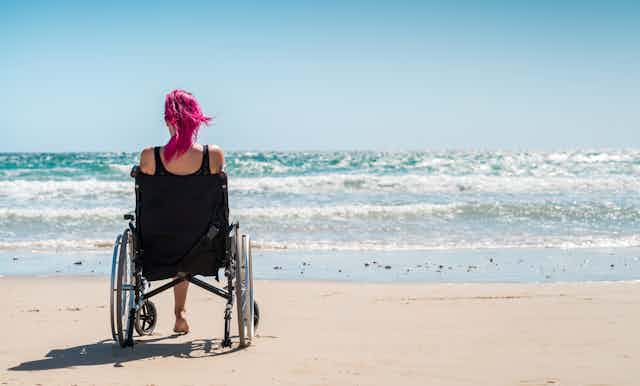A woman on a beach in a wheelchair