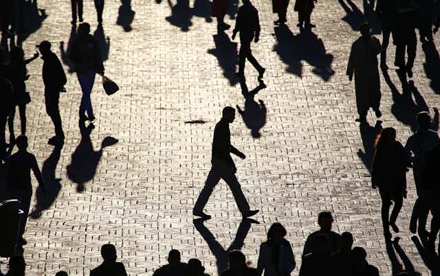 Man walk alone across a crowded city square