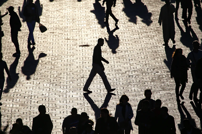 Man walk alone across a crowded city square