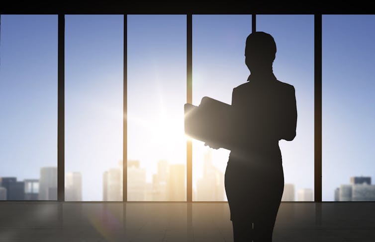 Silhouette of a businesswoman standing alone in an office