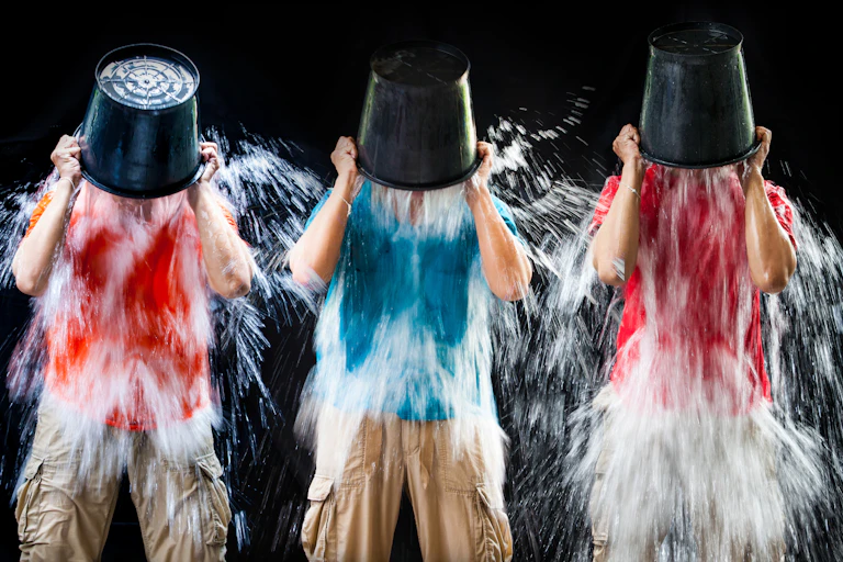 Tres hombres vertiendo sobre sus cabezas cubos de agua helada.
