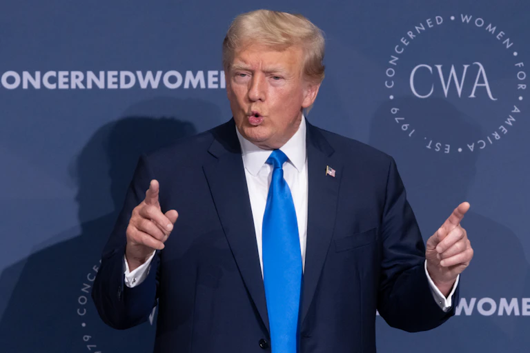 DOnald Trimp gestures with both hands as he delivers a speech.
