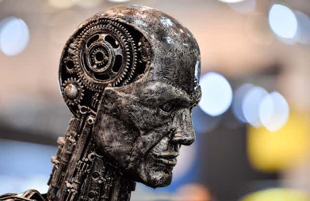 Escultura no formato de uma cabeça humana com a parte interna do crânio exposta, onde se vê engrenagens mecânicas no lugar do cérebro