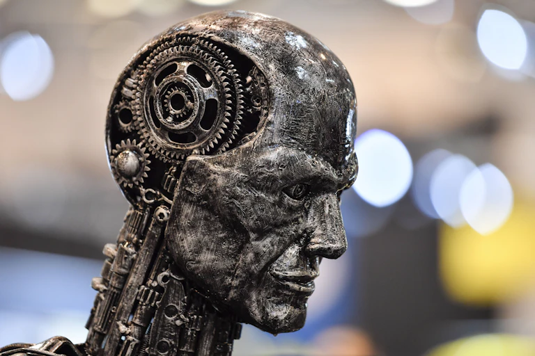 Escultura no formato de uma cabeça humana com a parte interna do crânio exposta, onde se vê engrenagens mecânicas no lugar do cérebro