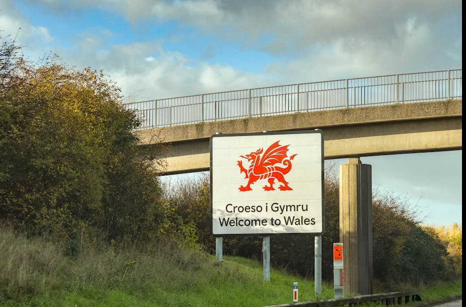 A bilingual sign with a large dragon saying 'Welcome to Wales'.