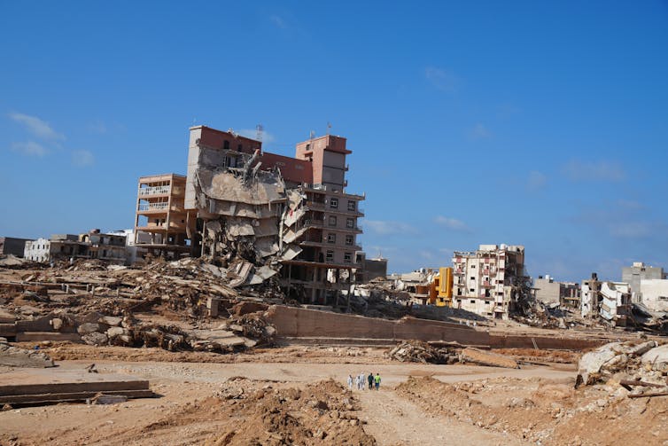 A disaster site with a half-demolished apartment building.