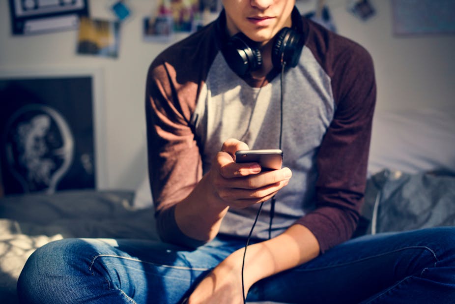 Adolescent écoutant de la musique grâce à son smartphone