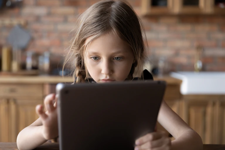 A young girl plays on an ipad