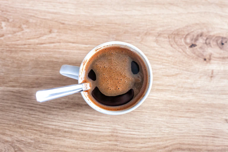 Coffee foam seems to form a smiling face