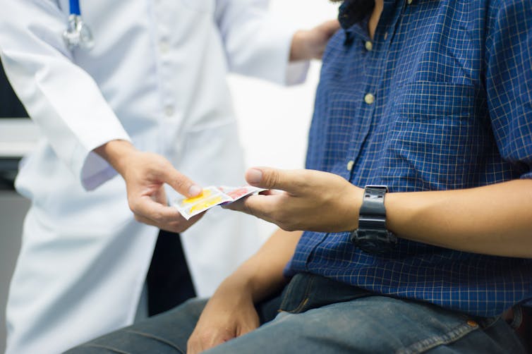 Clinician handing patient condoms