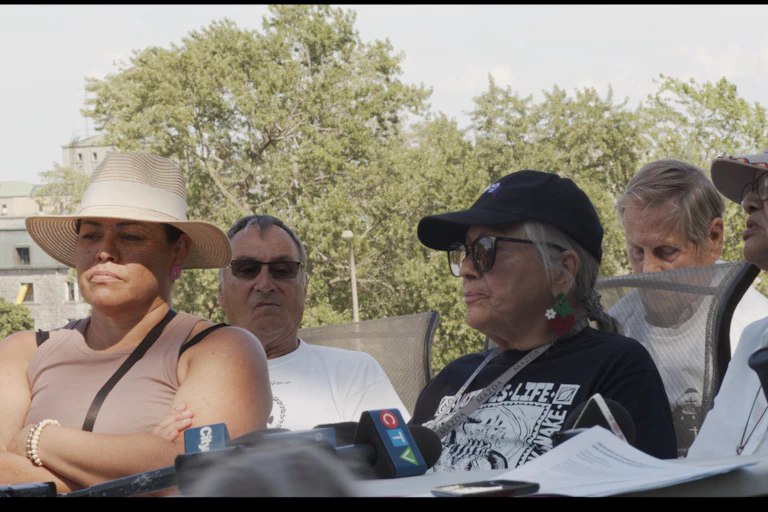Three Indigenous women holding a press conference