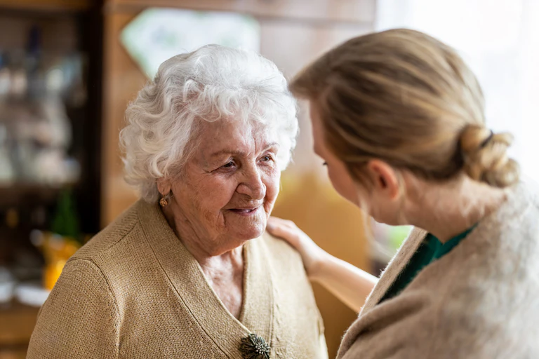Une femme plus âgée parle avec une femme plus jeune, dos à la caméra.