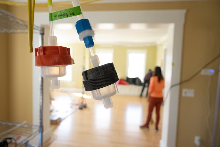 A view through a glass door shows tubes taped to the glass with collection devices.